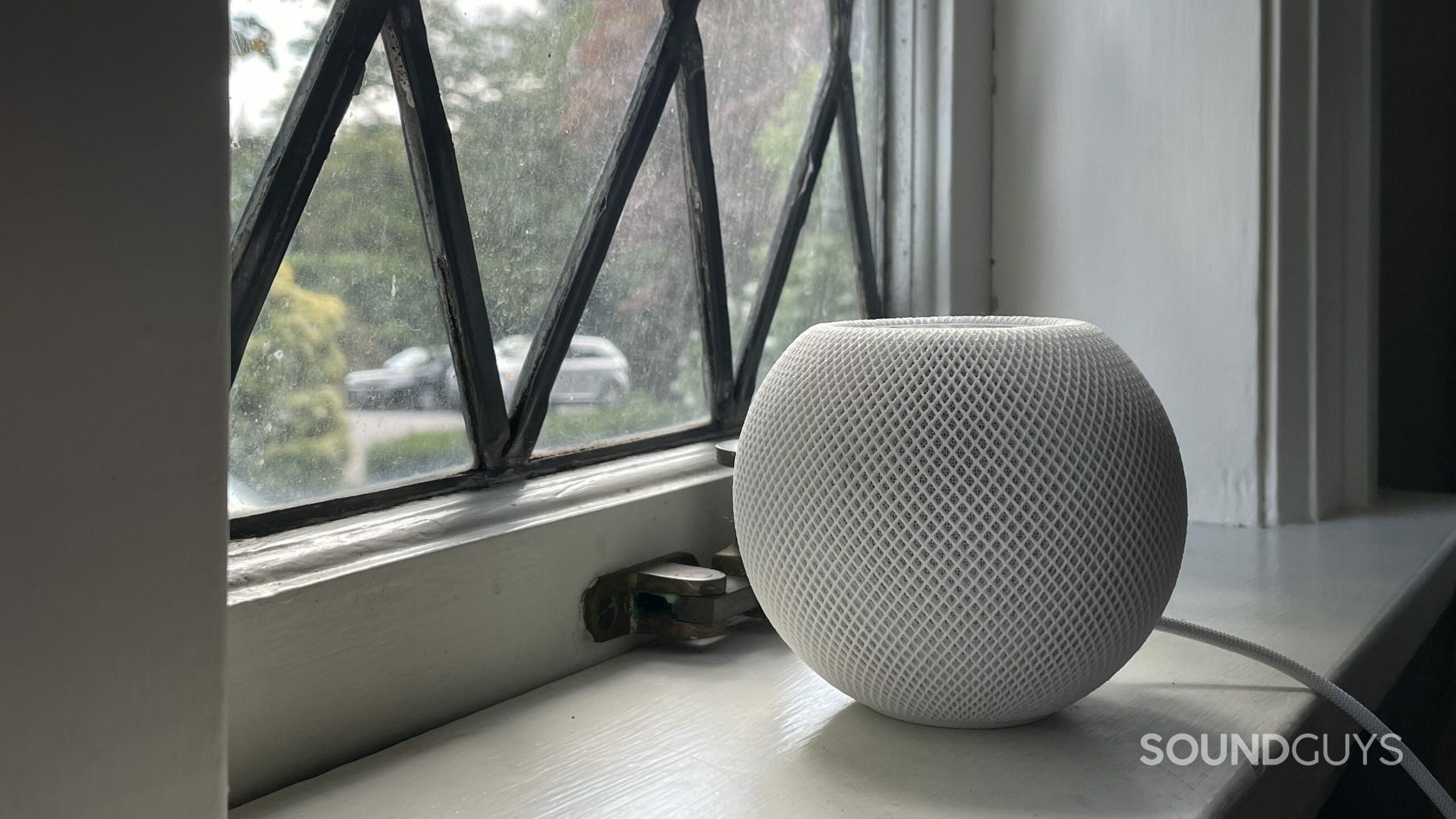 Apple Homepod mini window Apple HomePod mini resting on a windowsill.