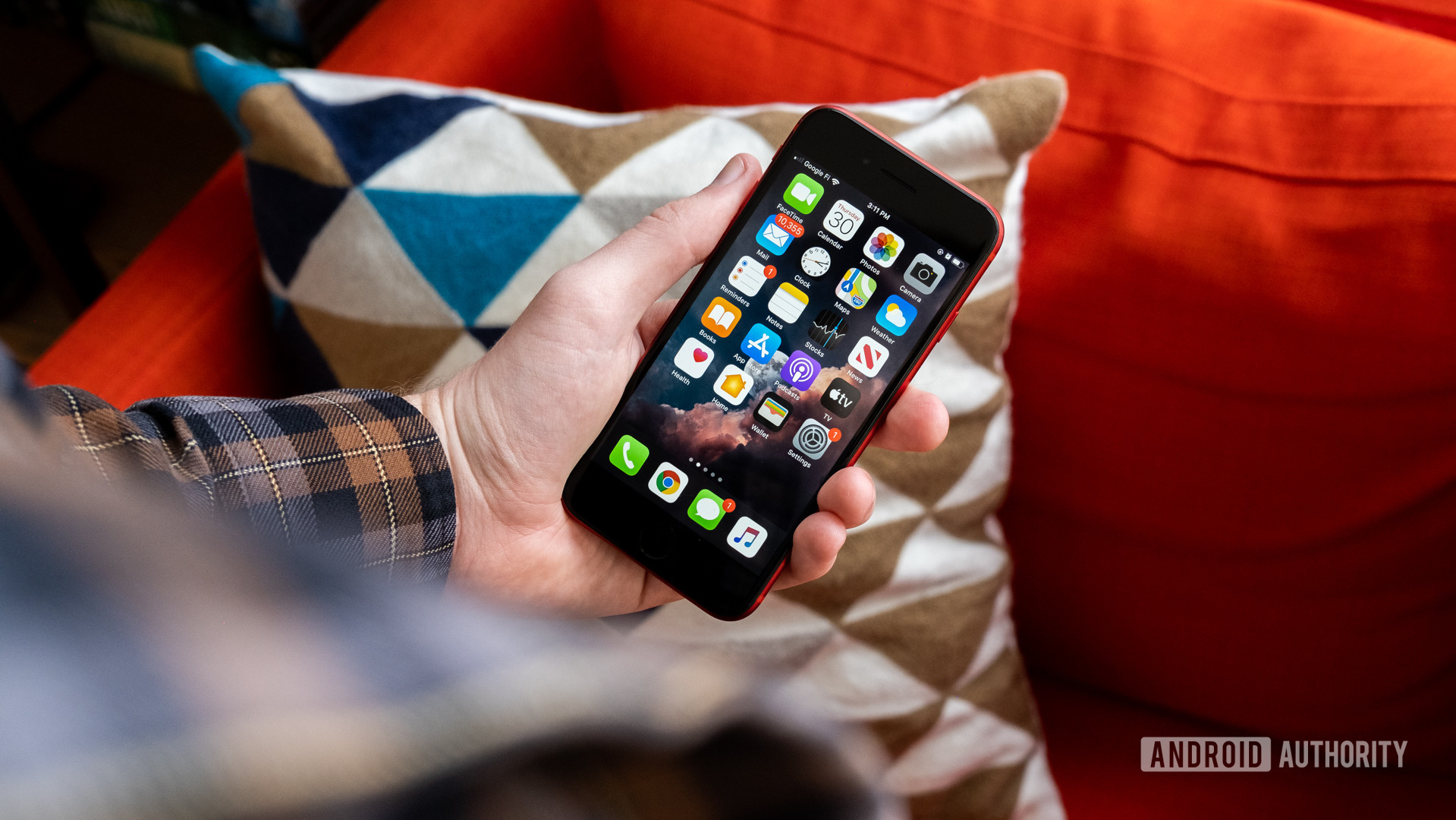 iPhone-SE-in-hand A photo of a man holding the Apple iPhone SE, with the screen on.