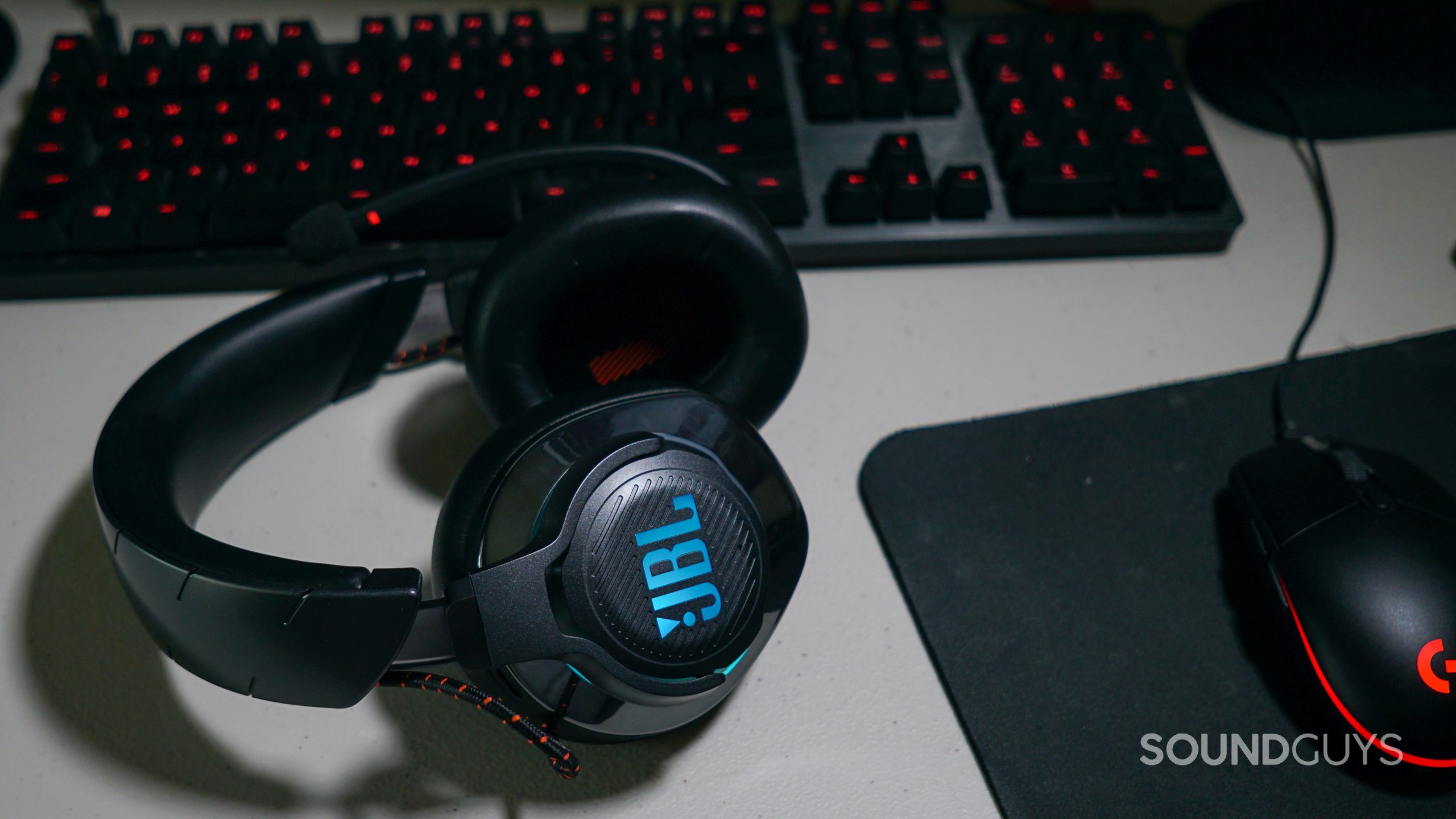 JBL Quantum 800 PC Shot WIDE The JBL Quantum 800 lays on a desk next to a Logitech gaming keyboard and mouse.