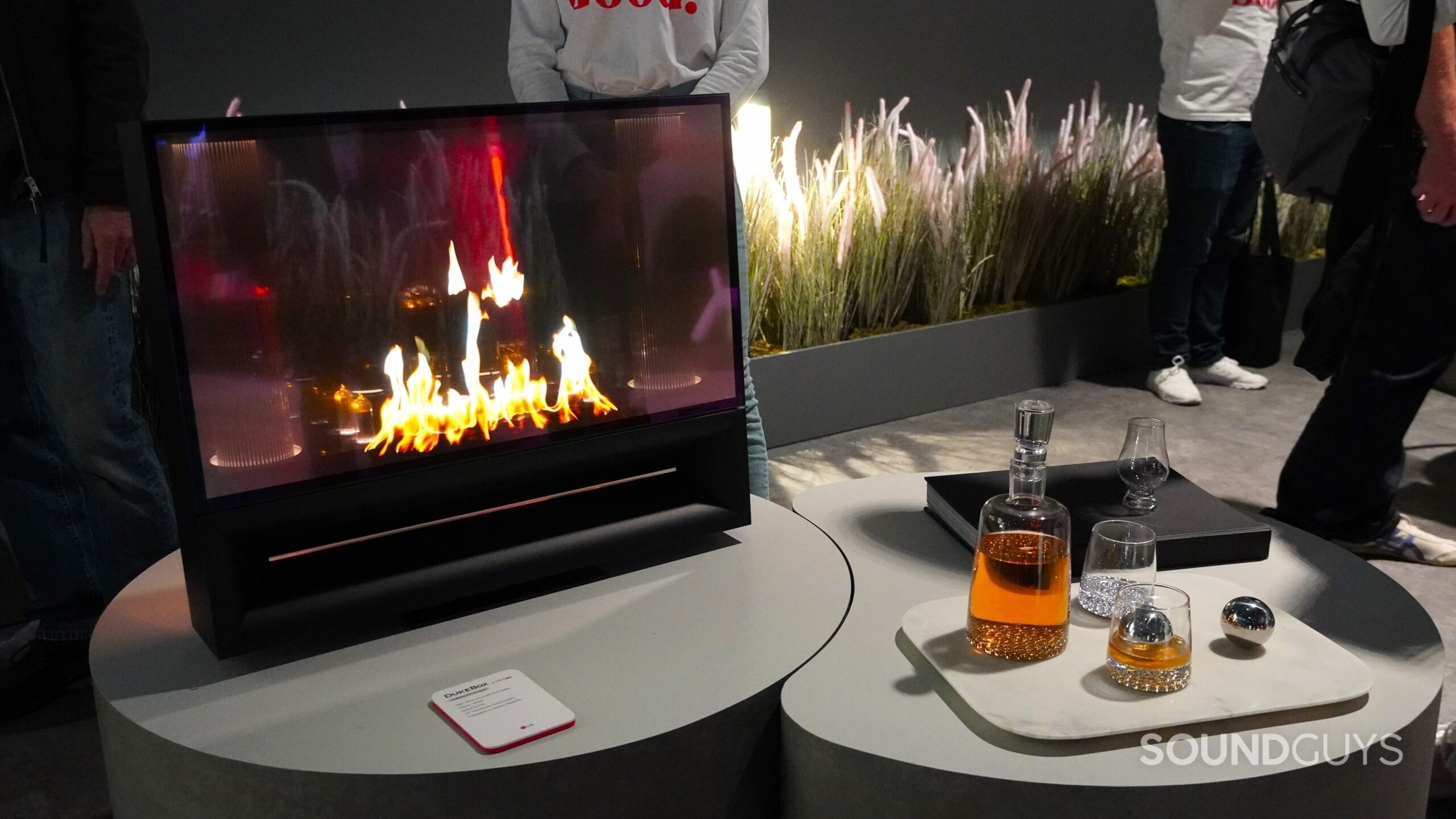 LG DukeBox with whiskey LG DukeBox fireplace on screen with whiskey and glasses