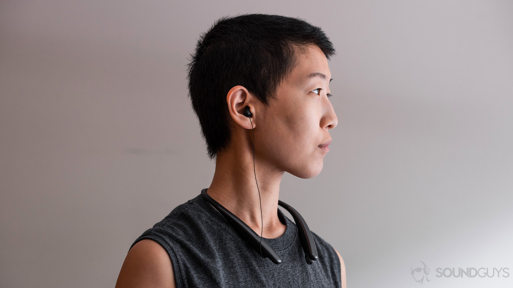 LG Tone Style SL6s woman wearing neckband retractable earbuds A woman wearing the LG Tone Style SL6s wireless neckband earbuds in profile view.