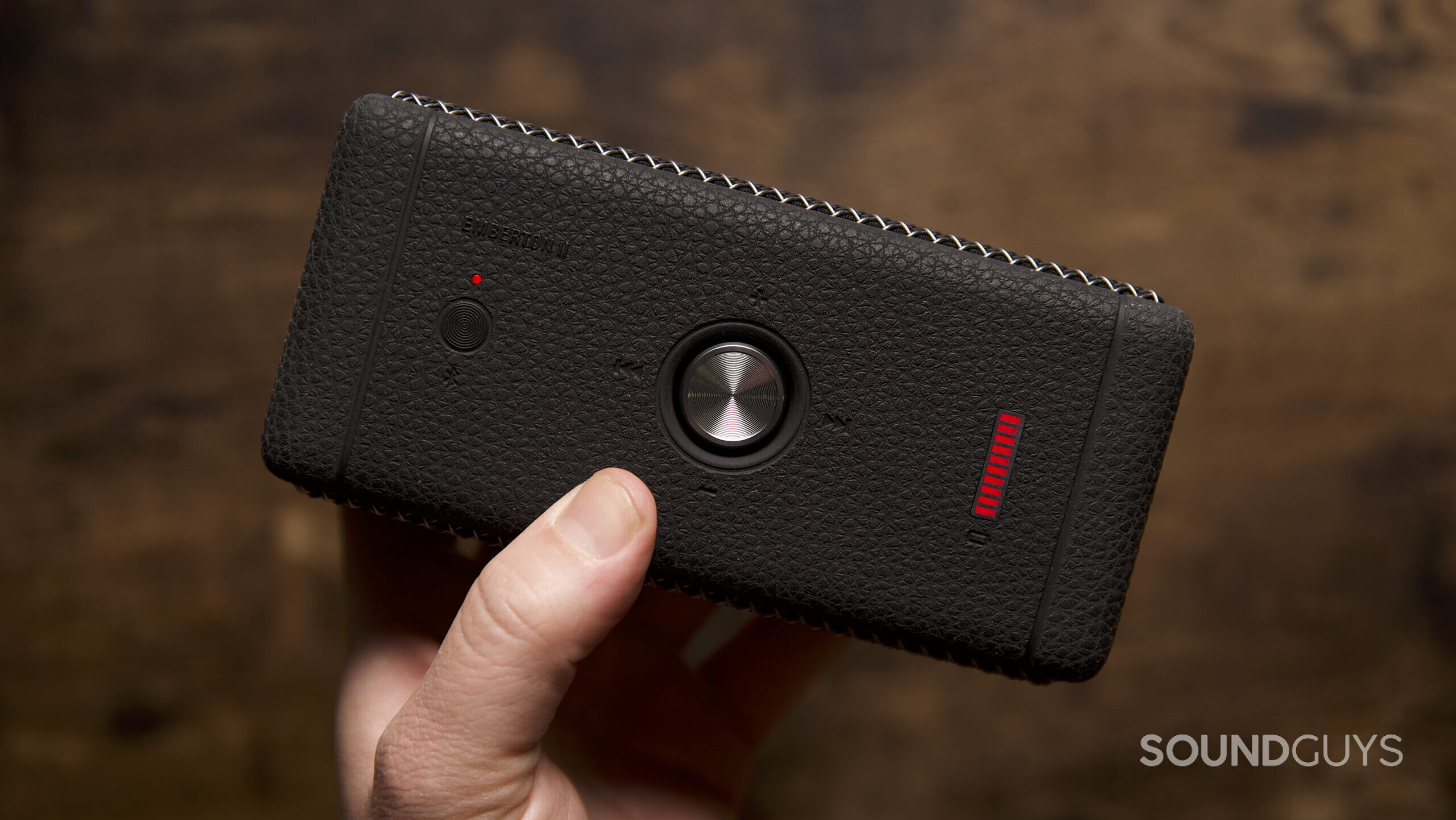 Marshall Emberton II controls A hand holding the Marshall Emberton II speaker, showing the controls and power level.
