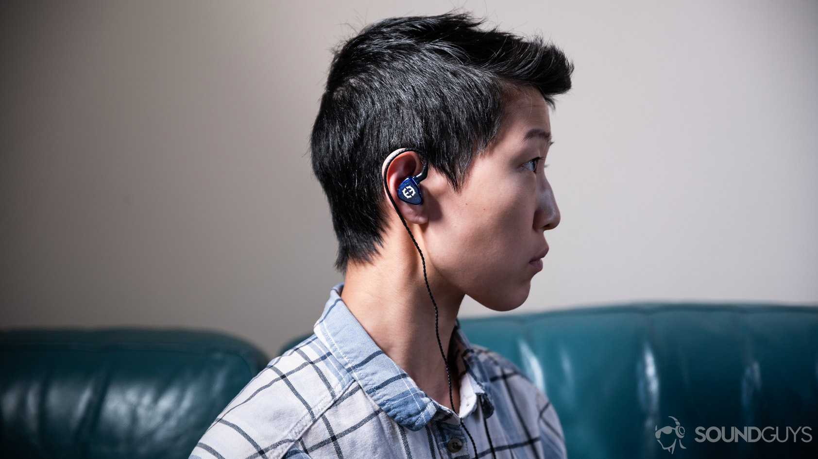 Massdrop x Empire Ears Zeus-woman wearing premium IEMs A photo of the Massdrop x Empire Ears Zeus earbuds being worn by a woman looking to the right of the frame.