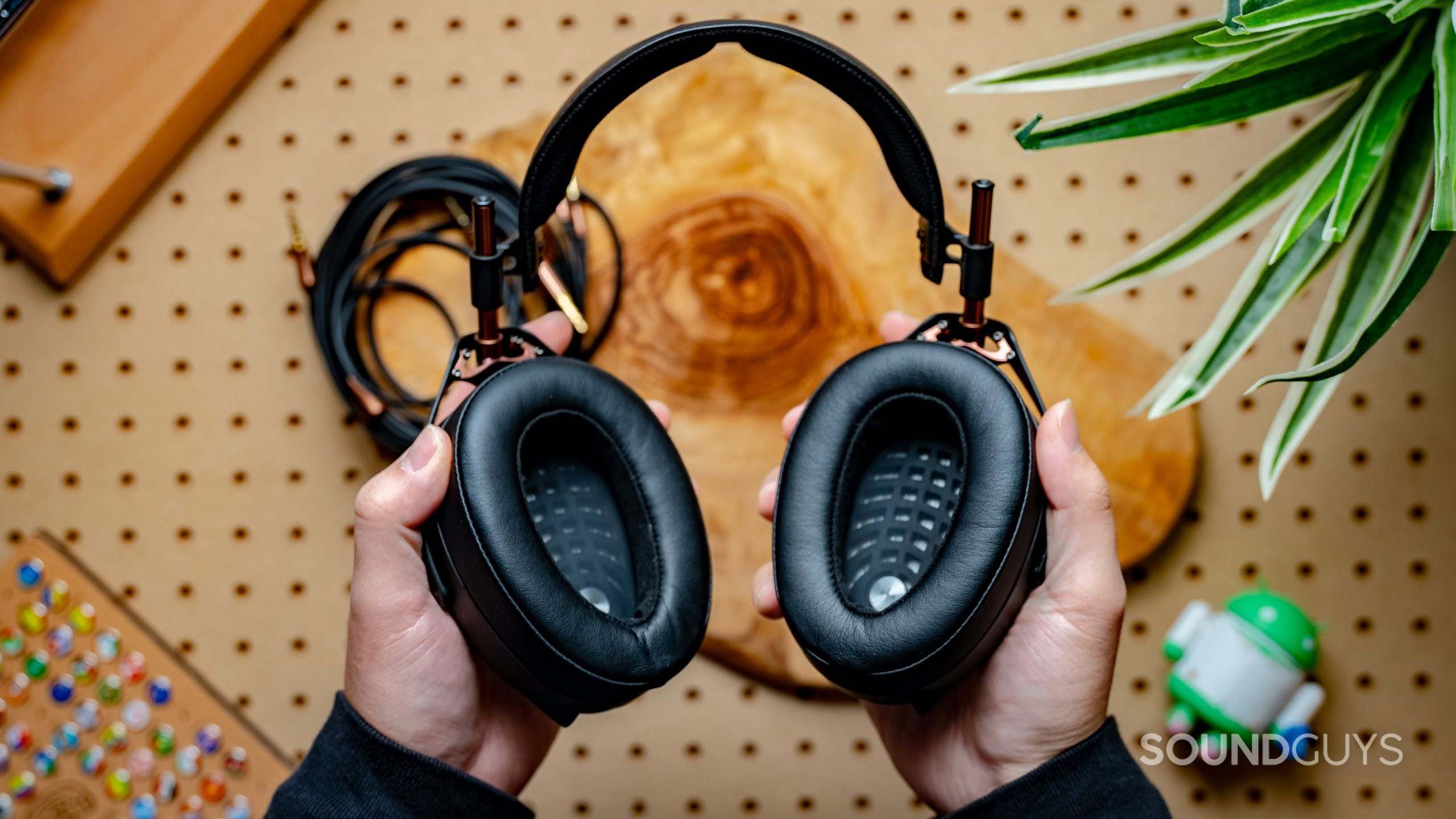 Meze Audio LIRIC Featured Image #2 A photo of the Meze Audio Liric headphones, held in a man's hands, showing the drivers.