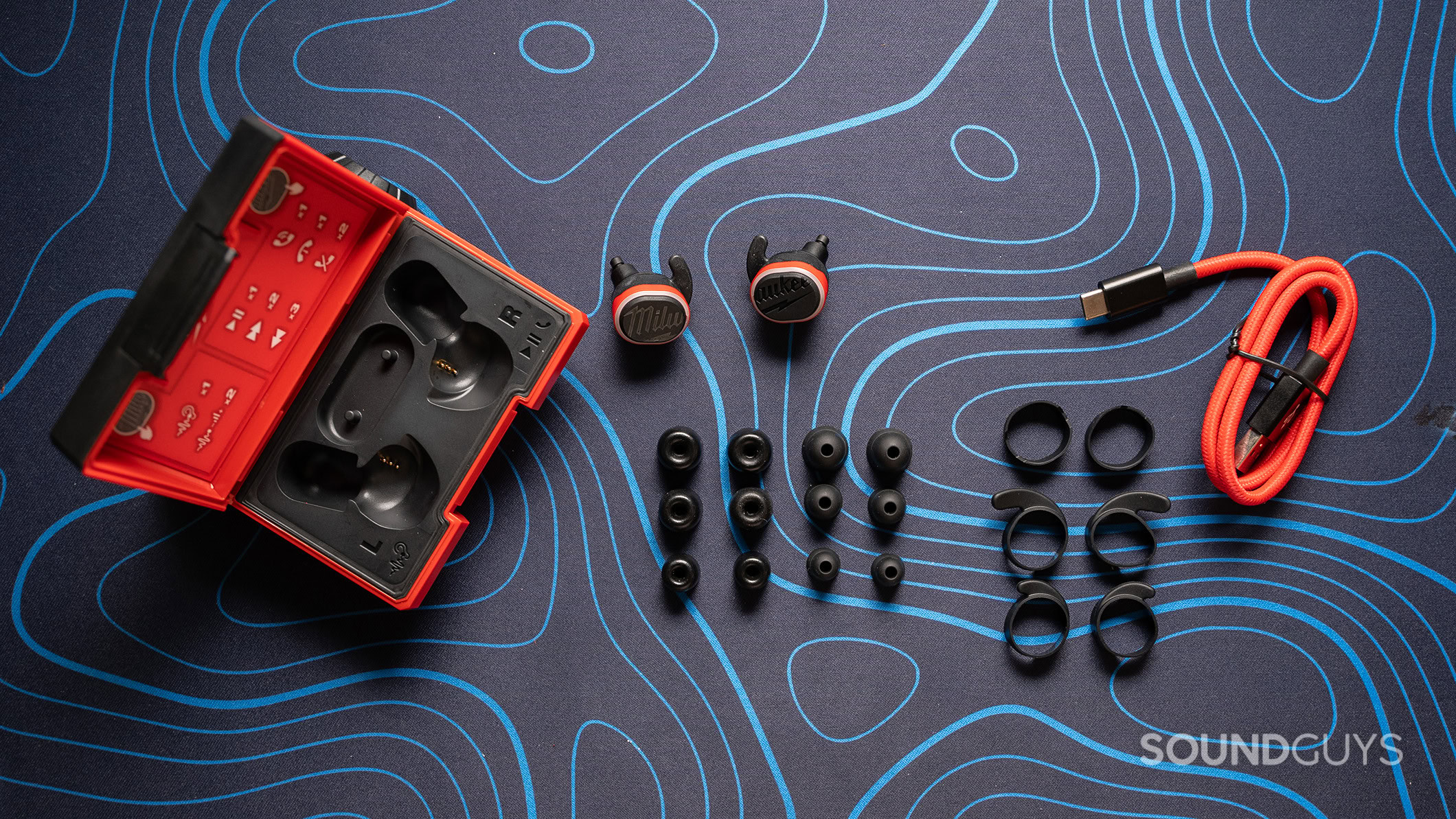 Milwaukee Earbuds accessories Milwaukee earbuds on a table with extra ear tips and a charging cable.
