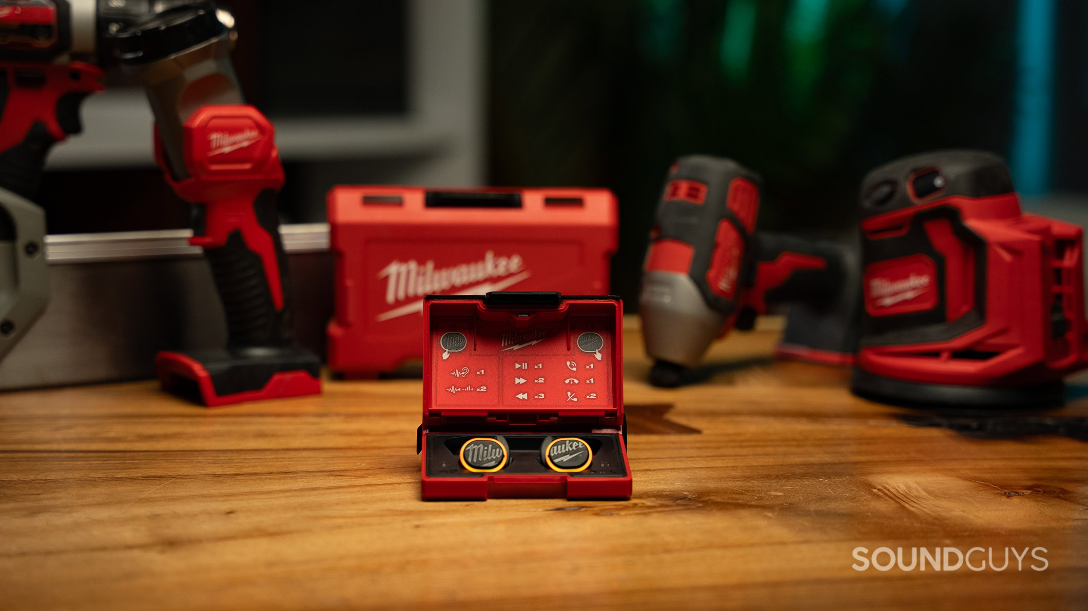 Milwaukee Earbuds next to equipment 4 The Milwaukee REDLITHIUM Jobsite Earbuds in front of some Milwaukee power tools on a table.