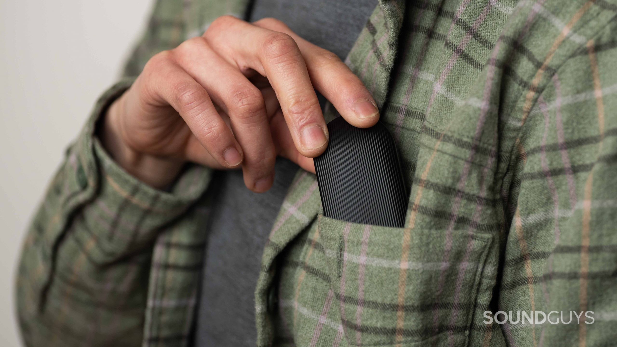 Mobvoi Earbuds Gesture true wireless earbuds pocket A hand inserts the Mobvoi Earbuds Gesture case into a breast pocket.