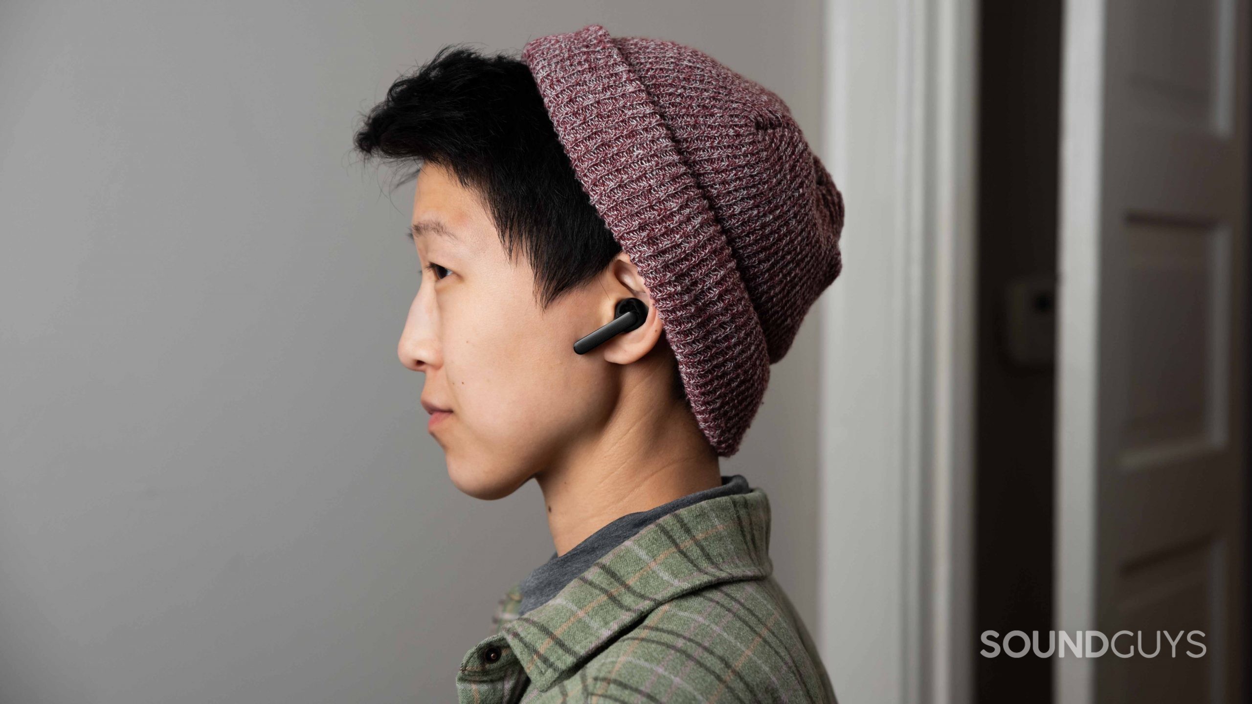 Mobvoi Earbuds Gesture woman wears true wireless earbuds A woman wears the Mobvoi Earbuds Gesture true wireless earbuds in profile to illustrate the stemmed design.