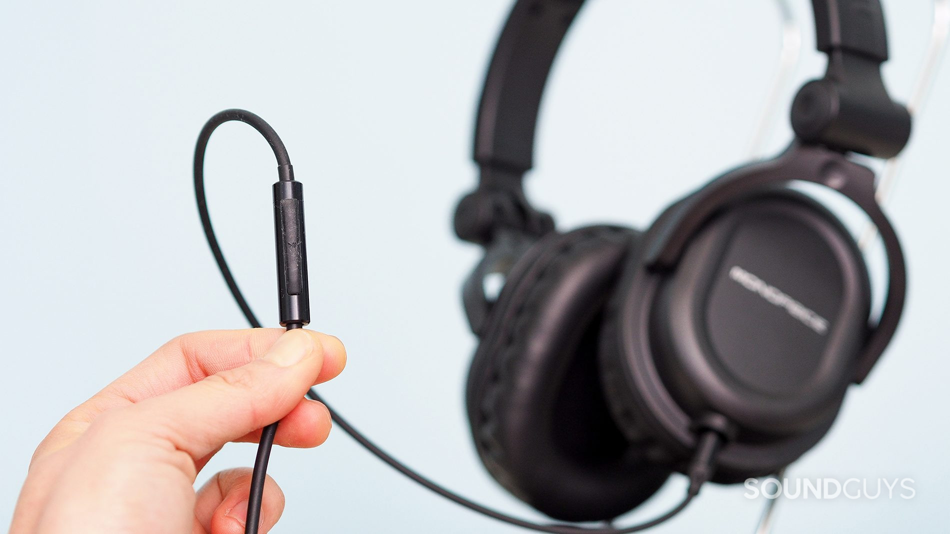 Monoprice 8323_5_LK_SG Monoprice 8323 headphone's remote mic held by someone's hand.