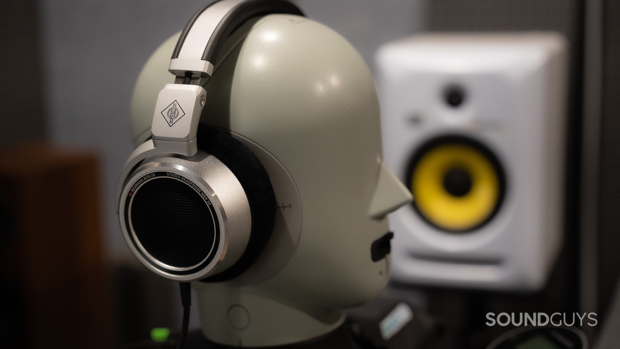 Neumann NDH 30 testing head Neumann NDH 30 headphones on a testing head next to a monitor speaker.