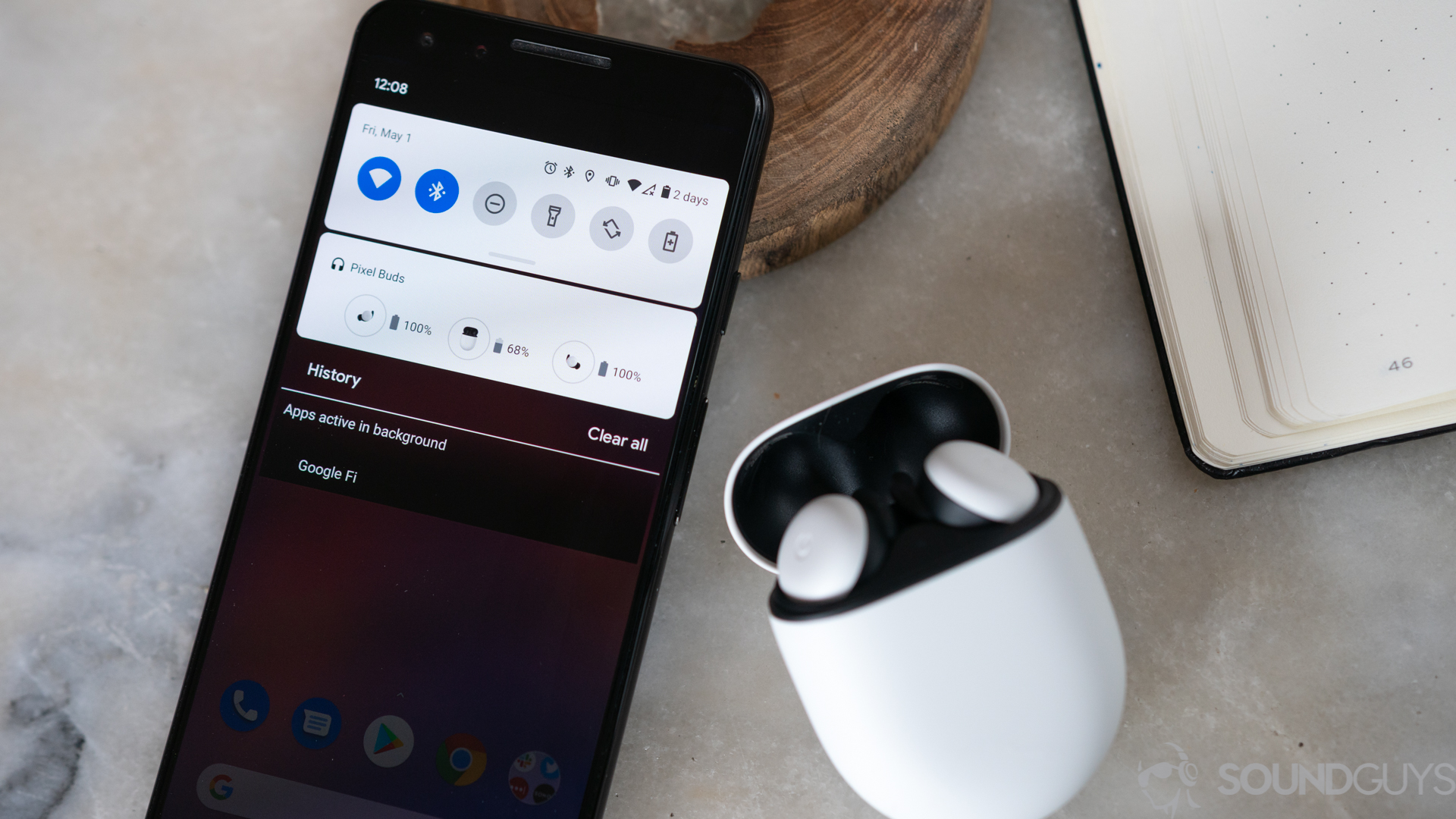 New Google Pixel Buds connected to the Pixel 3 A photo of the white Google Pixel Buds on a marble table next to Pixel 3 with battery card displayed