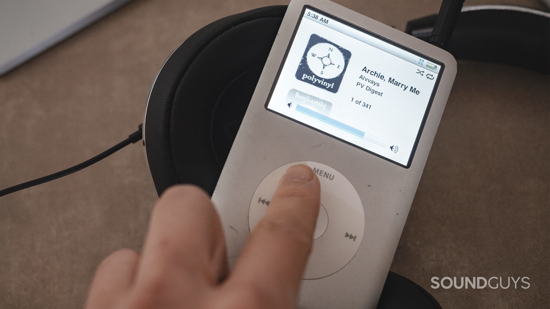 NIHL_LK noise-induced hearing loss: A finger turning up the volume on an iPod Classic (silver).