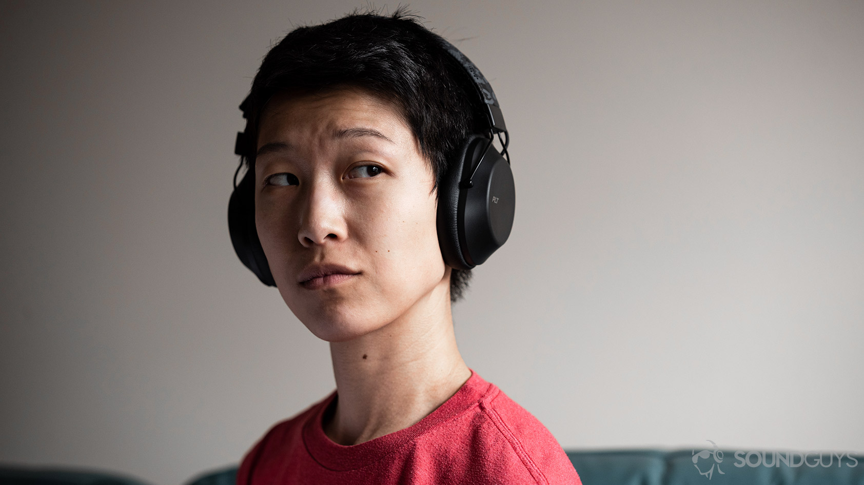 Plantronics BackBeat Fit 6100-workout headphones woman wearing A woman wears the Plantronics BackBeat Fit 6100 workout headphones against an off-white wall.