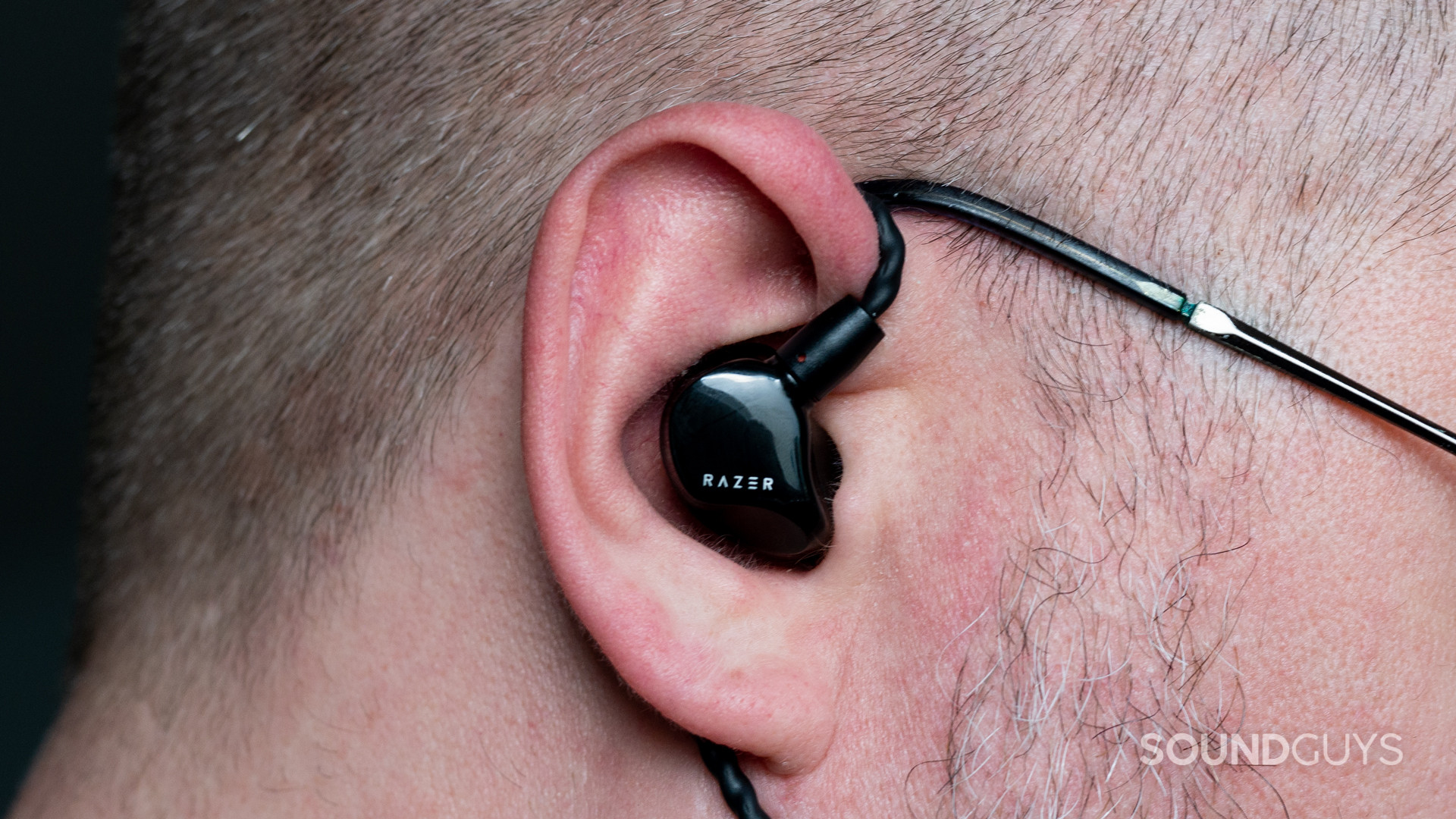 razer-moray-wear The Razer Moray IEM being used by a short-haired, bespectacled man.