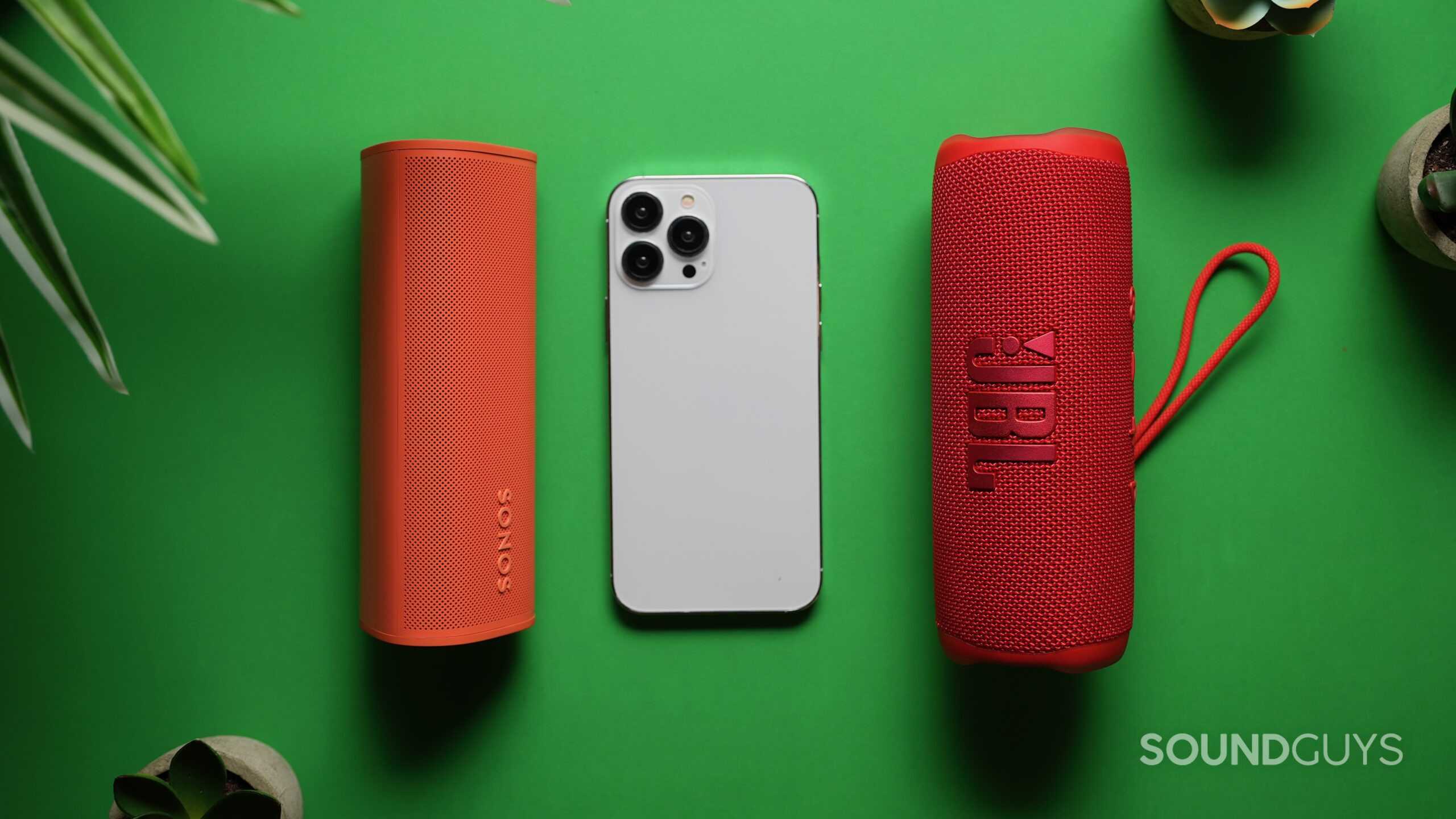 Roam 2 vs Flip 6 3 The Sonos Roam 2 and JBL Flip 6 with an iPhone 15 max in the middle showing size difference.