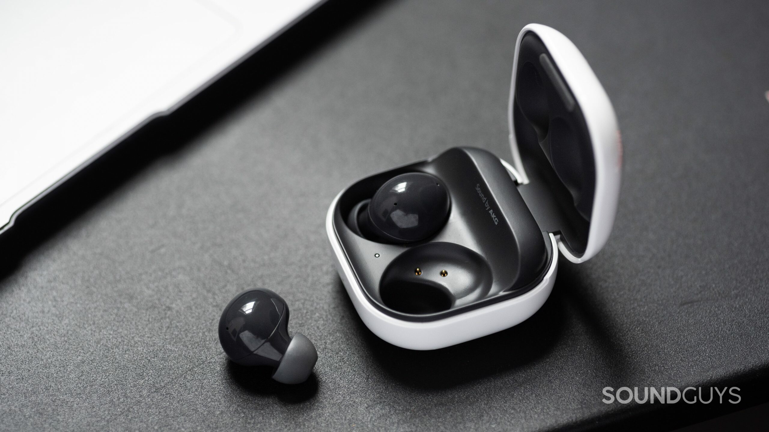 Samsung Galaxy Buds 2-noise canceling true wireless earbuds-7 The Samsung Galaxy Buds 2 noise canceling true wireless earbuds with one 'bud out of the open, angled charging case.