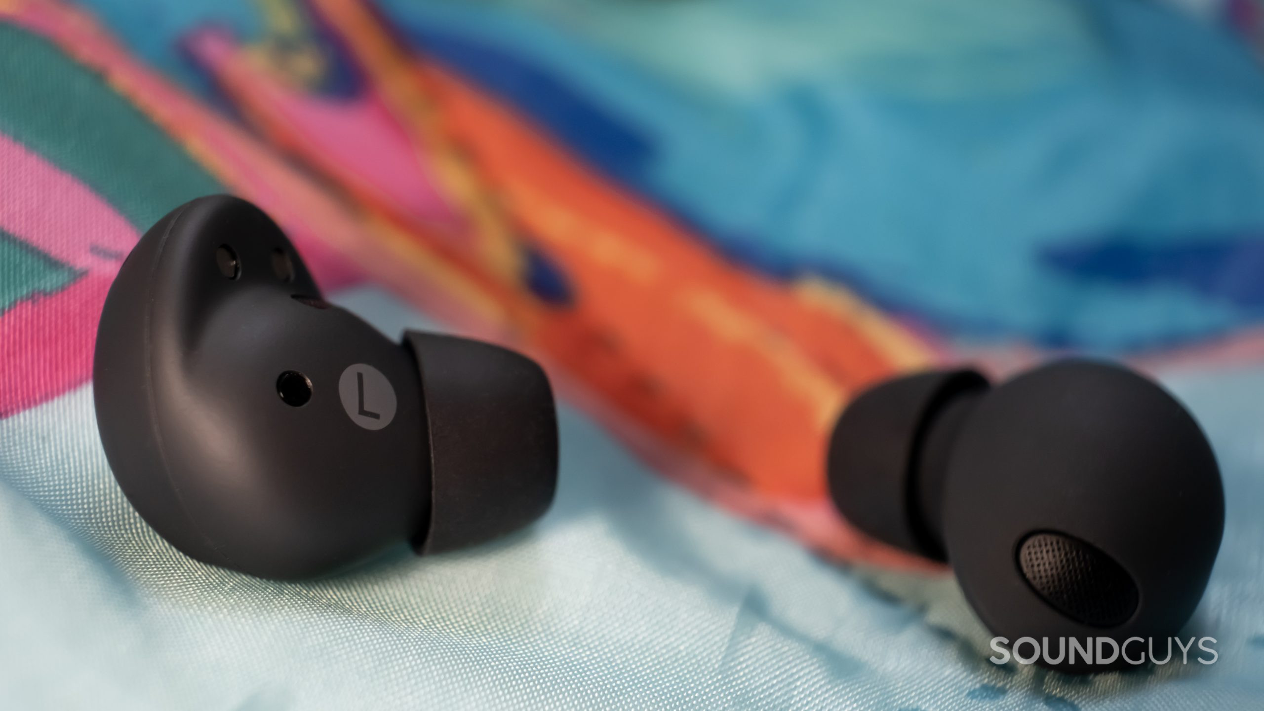 samsung-galaxy-buds-2-pro-macro-buds A macro close up of the Samsung Galaxy Buds 2 Pro shows the inner and outer housing, including the ear tips and vent, while resting on a colorful blanket.