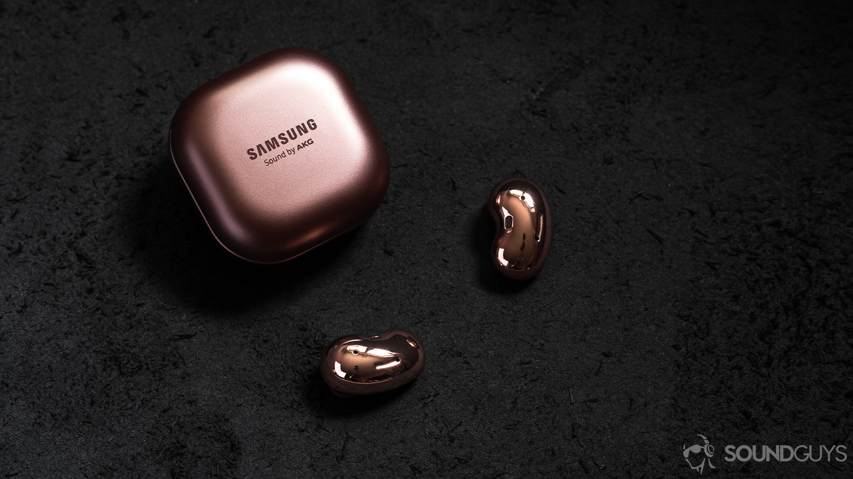 Samsung Galaxy Buds Live noise canceling true wireless earbuds case closed earbuds A picture of the Samsung Galaxy Buds Live noise canceling true wireless earbuds outside of the closed case and on a black surface.