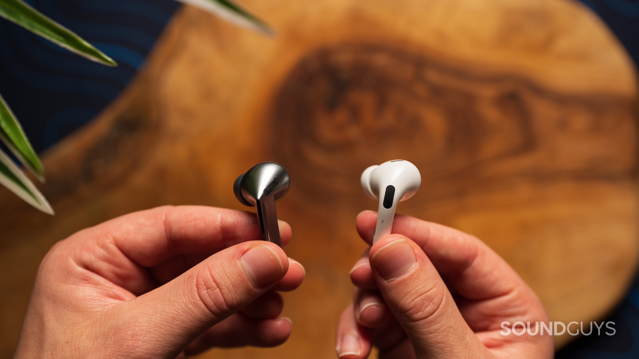 Samsung Galaxy Buds3 Pro vs Apple AirPods Pro (2nd generation) microphones 2 A hand holds a Galaxy Buds3 Pro earbud and a AirPods Pro 2 earbud.
