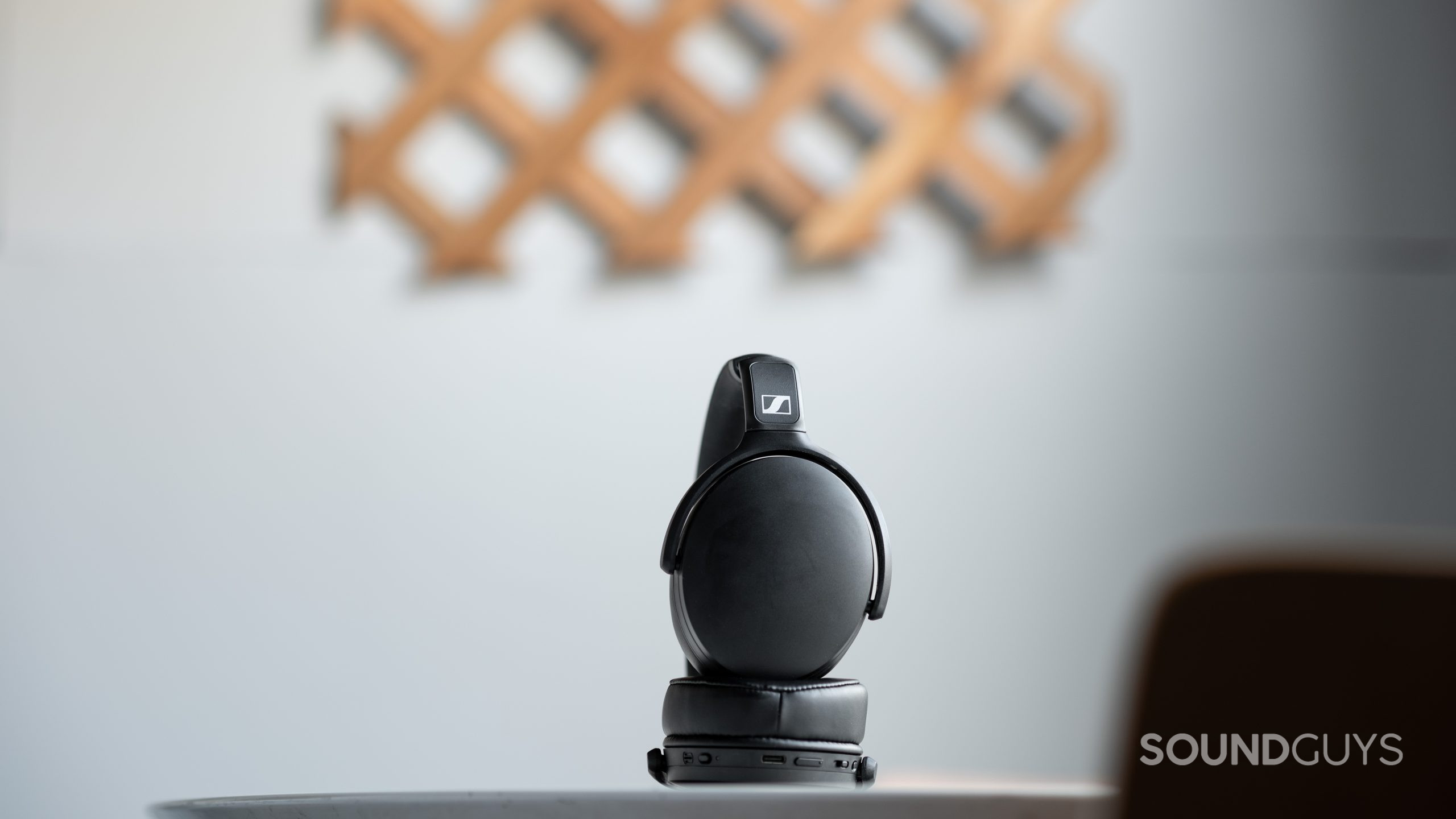 Sennheiser HD 350BT_folded ear cups full The Sennheiser HD 350BT Bluetooth headphones folded slightly on a table in front of an off-white wall.