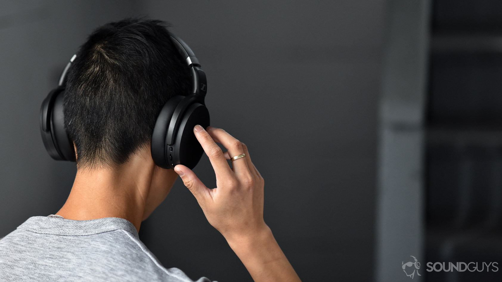 Sennheiser HD 450BT-noise canceling headphones controls 2 The Sennheiser HD 450BT noise canceling headphones worn by a woman as she adjusts the volume via the onboard controls on the right ear cup.