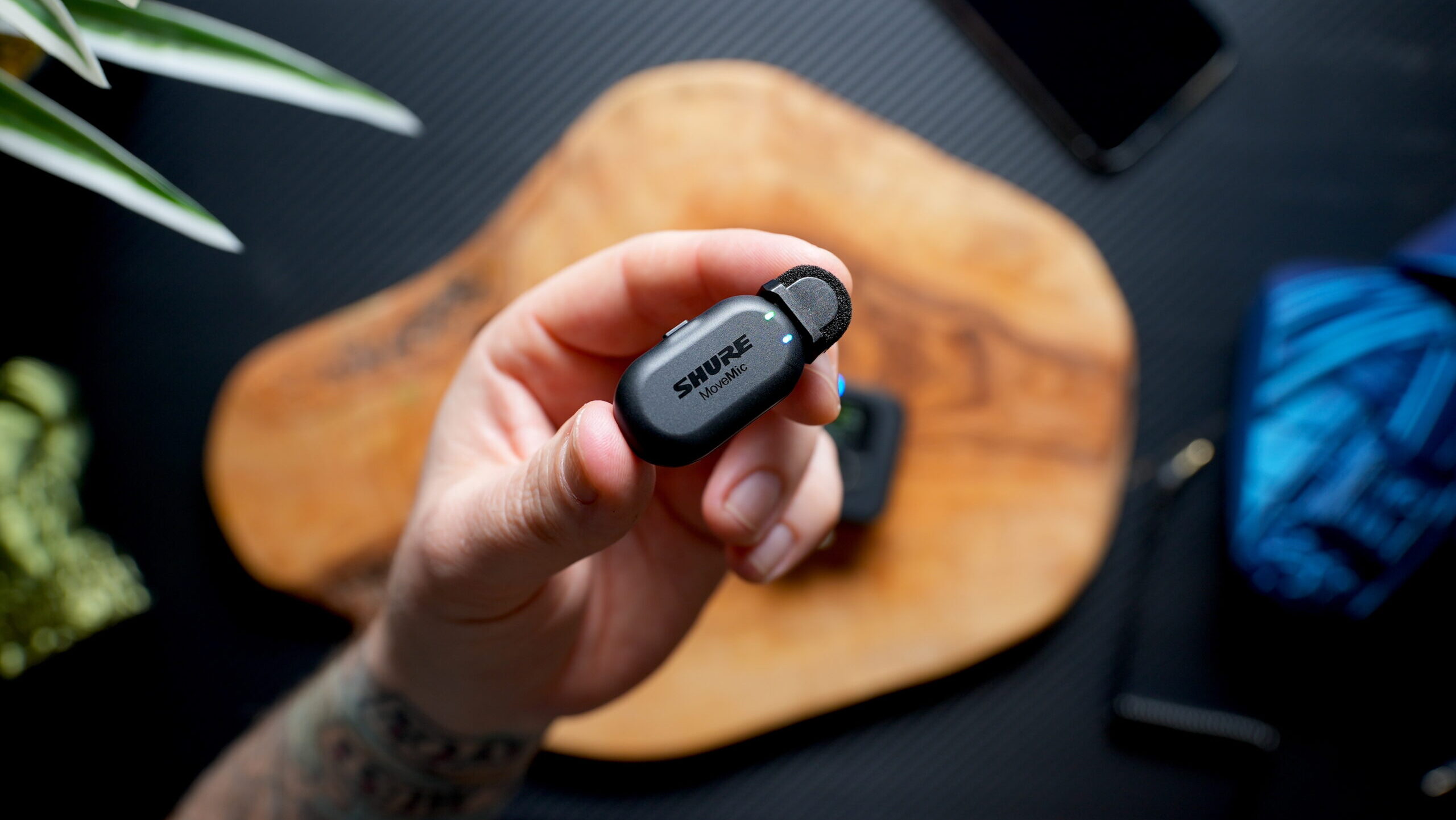 Shure MoveMic Transmitter 2 A hand holding a Shure MoveMic transmitter.