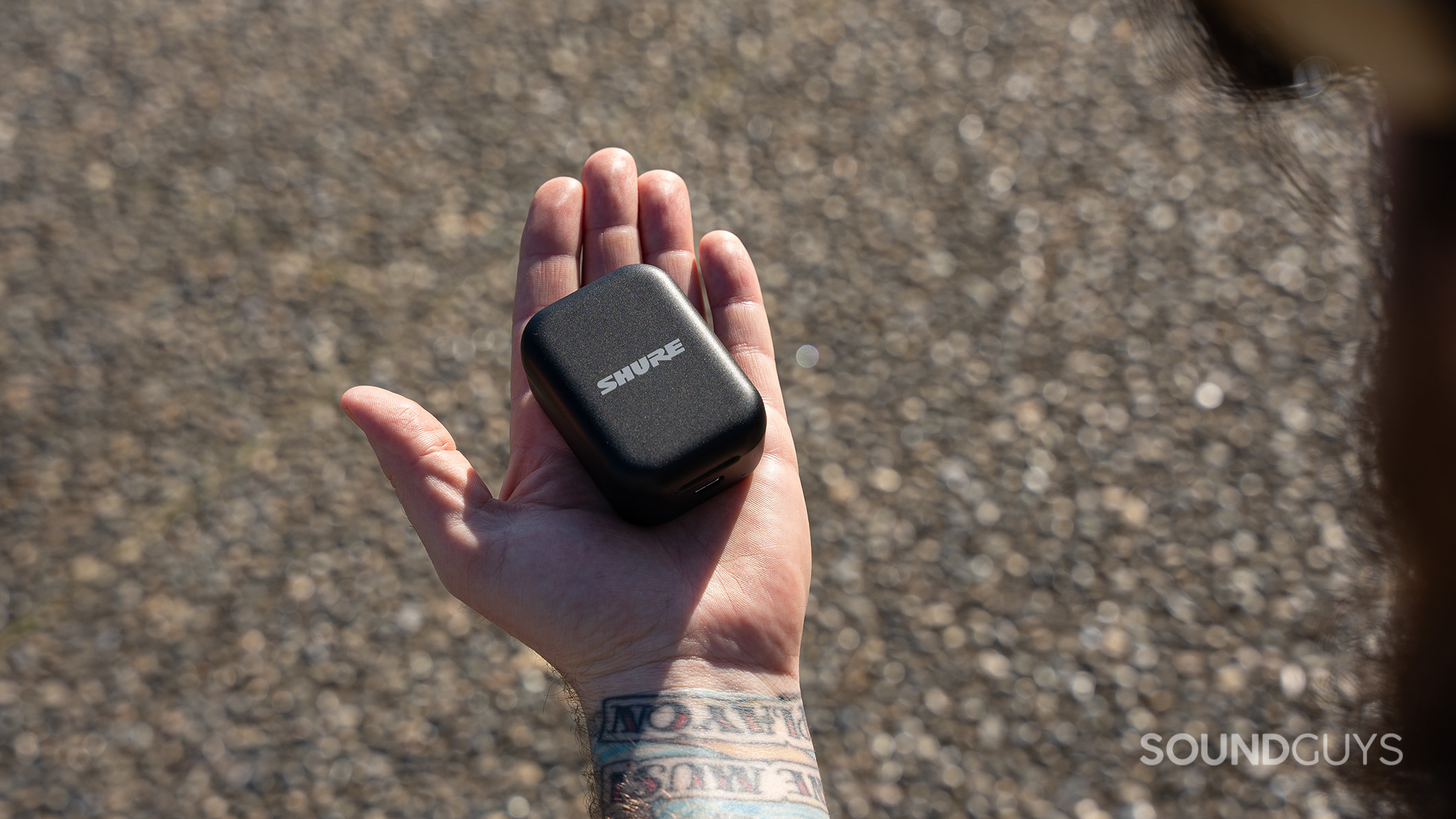 Shure MoveMic Two case close A Shure MoveMic charging case on the palm of an open hand