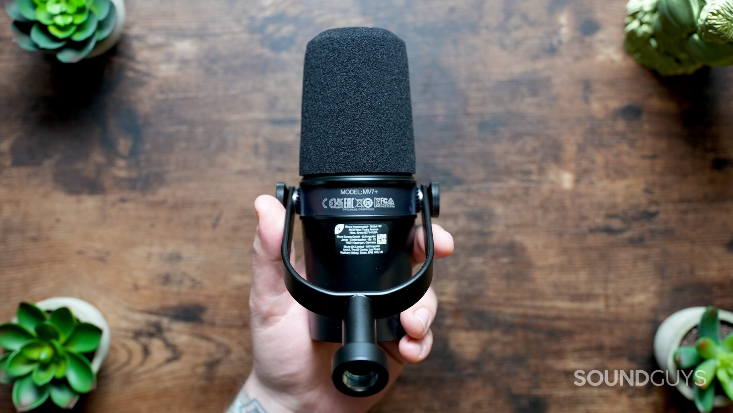 Shure MV7+_top down in hand 2 Top down shot, showing the underside of the Shure MV7+ microphone.