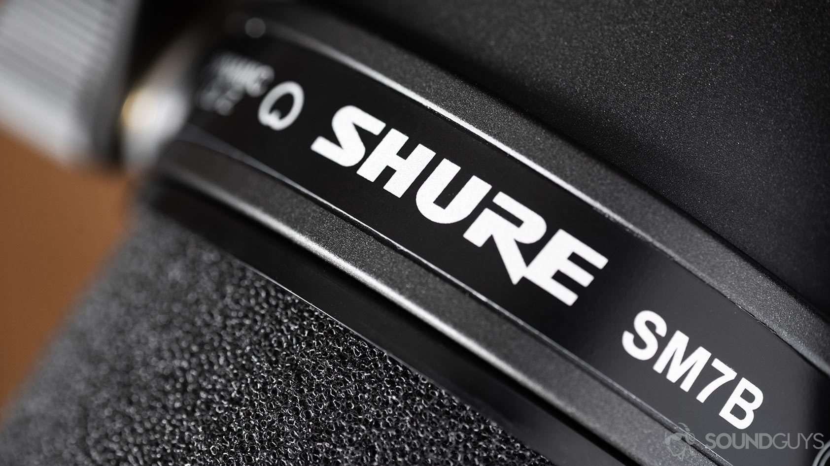 Shure-SM7B-logo.jpg A macro photo of the Shure SM7B, one of the best mics for YouTube, and the Shure logo and cardioid icon.