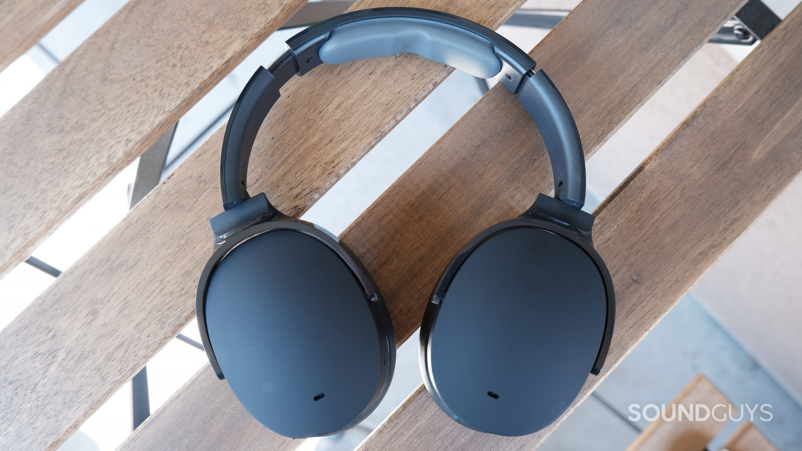skullcandy-hesh-anc-main The Skullcandy Hesh ANC on a brown wooden patio table with the ear cups folded down.