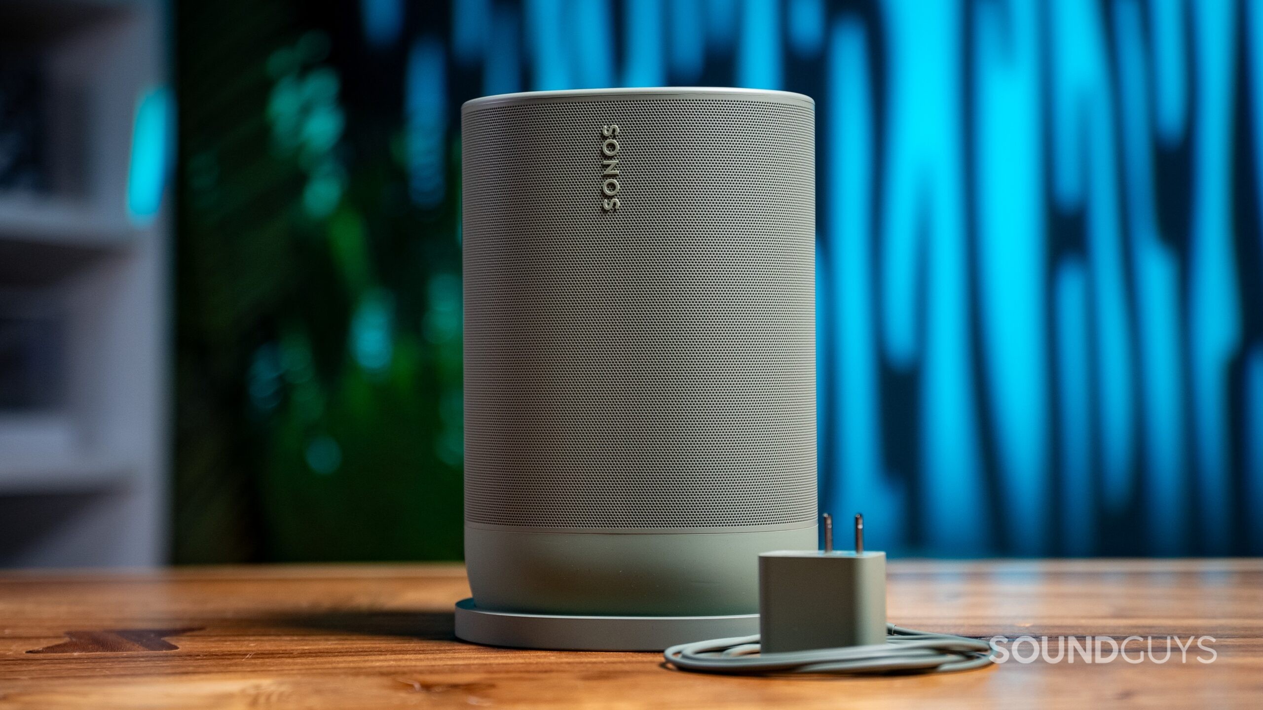 Sonos Move 2 Featured Image #1 The Sonos Move 2 in Olive shown with included charging accessories with a blue background.