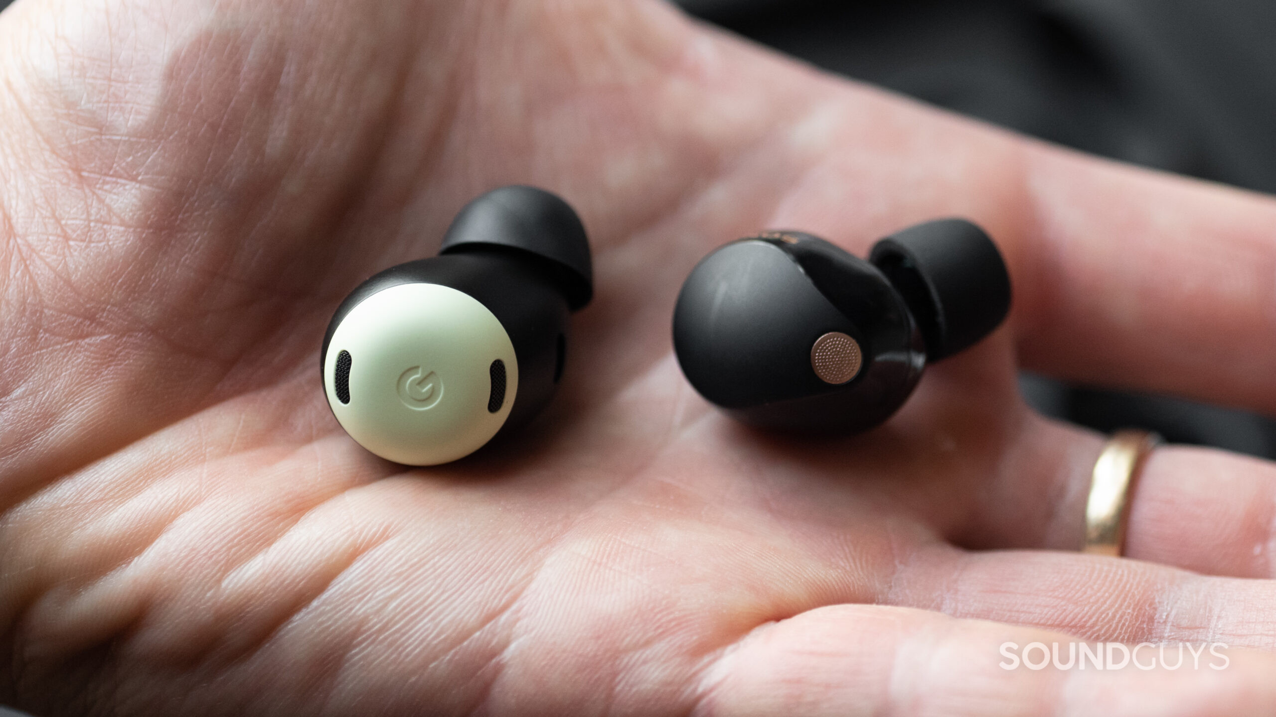 Sony WF-1000XM5 vs Google Pixel Buds Pro-2 A hand holds the Pixel Buds Pro and WF-1000XM5 earbuds.