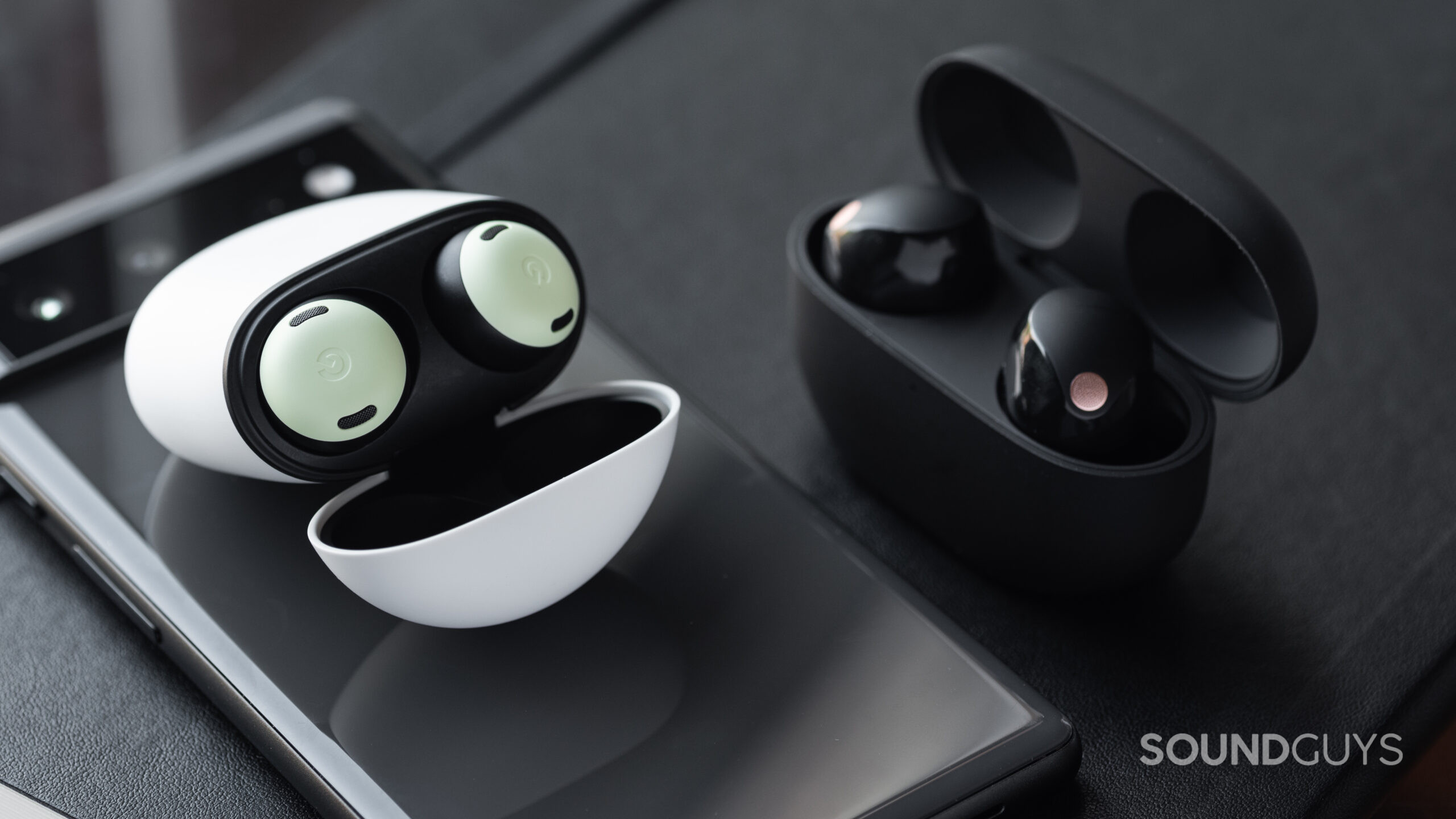Sony WF-1000XM5 vs Google Pixel Buds Pro-4 The Google Pixel Buds Pro and WF-1000XM5 cases next to each other with the earbuds showing.
