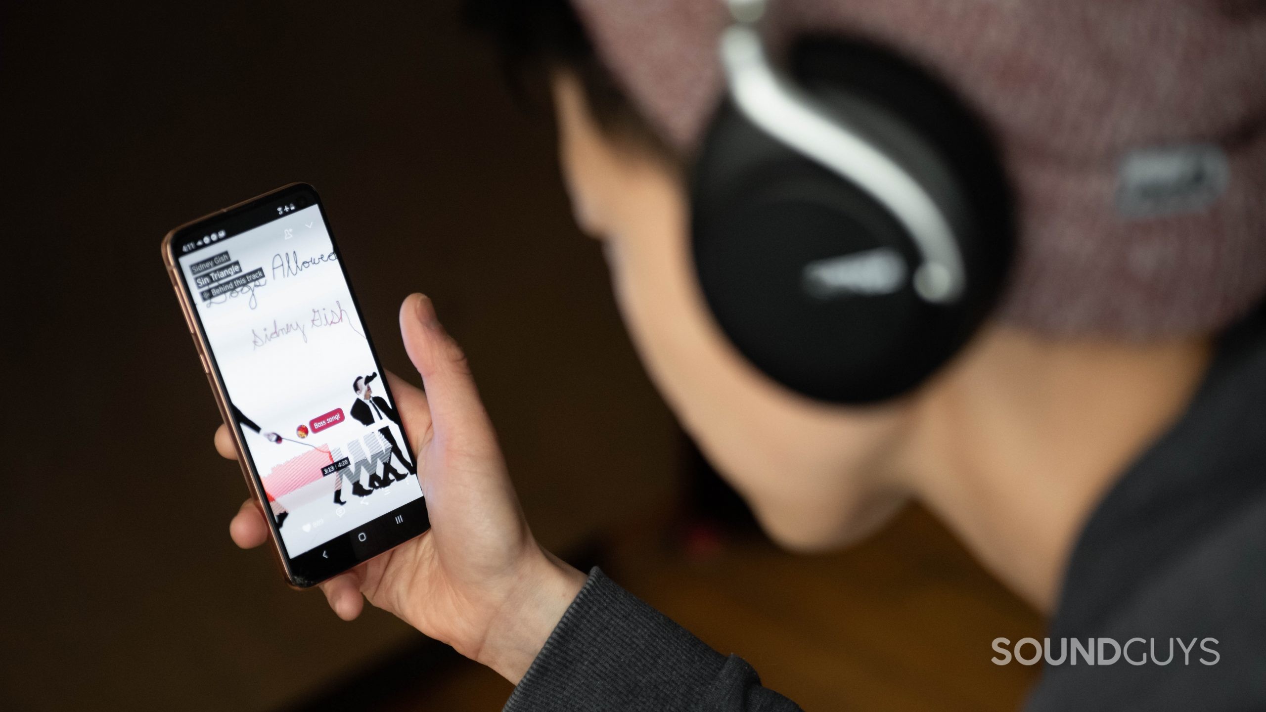 SoundCloud review-4 A woman listens to a song on SoundCloud from her smartphone.