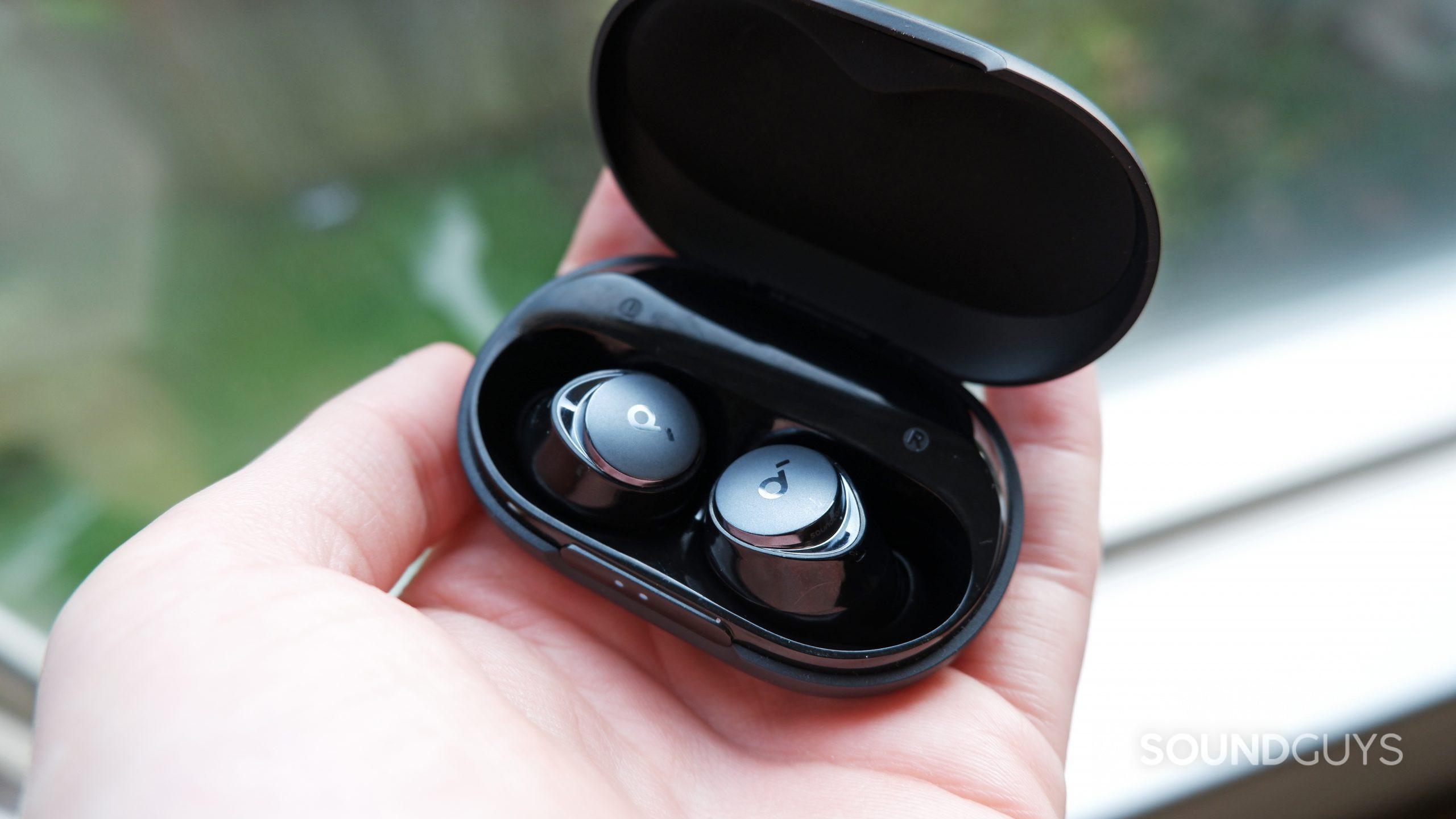 space-a40-open-case-hand The Anker Soundcore Space A40's case open with the earbuds inside, resting on a person's hand.