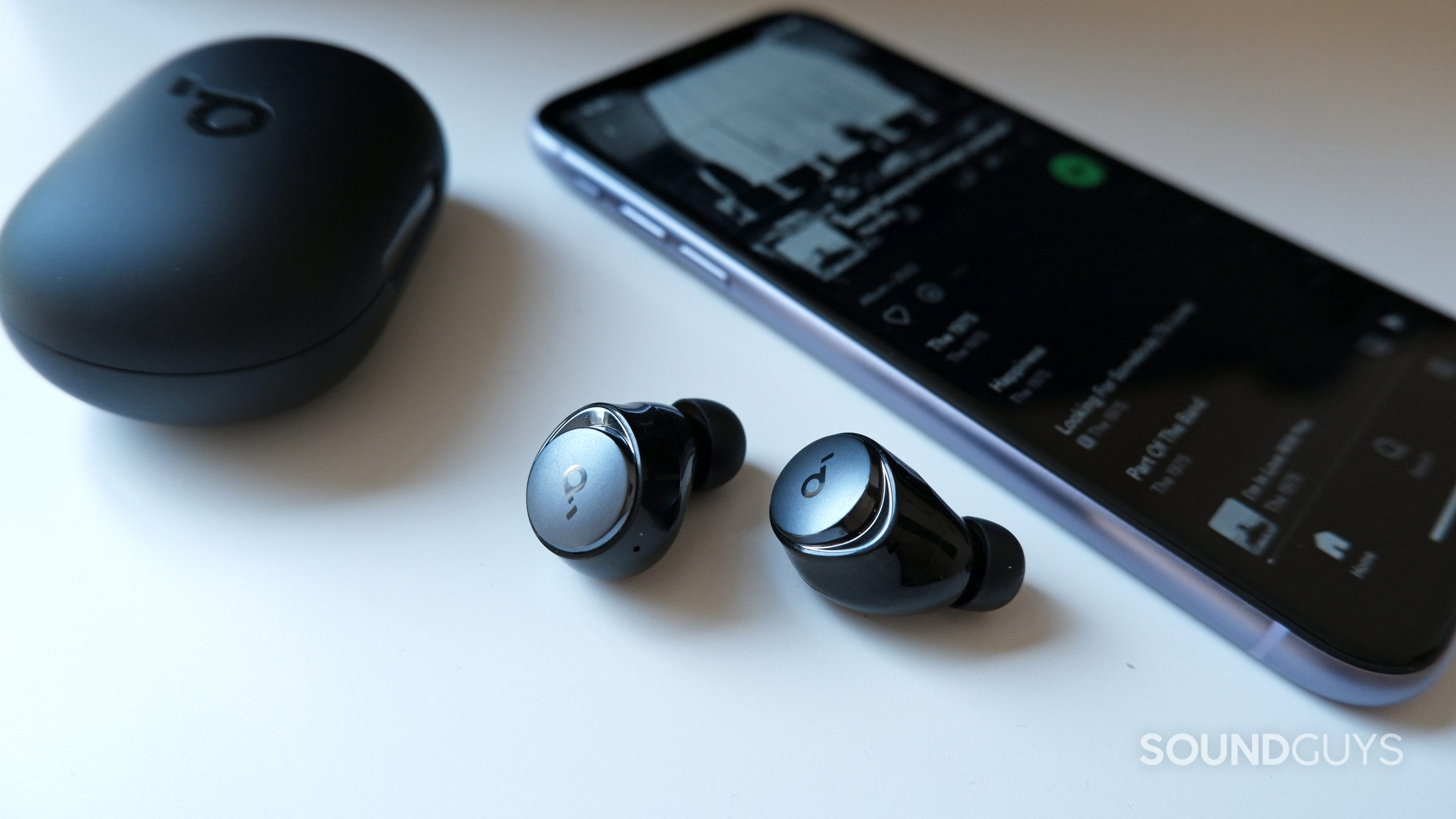 space-a40-phone The Anker Soundcore Space A40 earbuds beside a phone with spotify open.