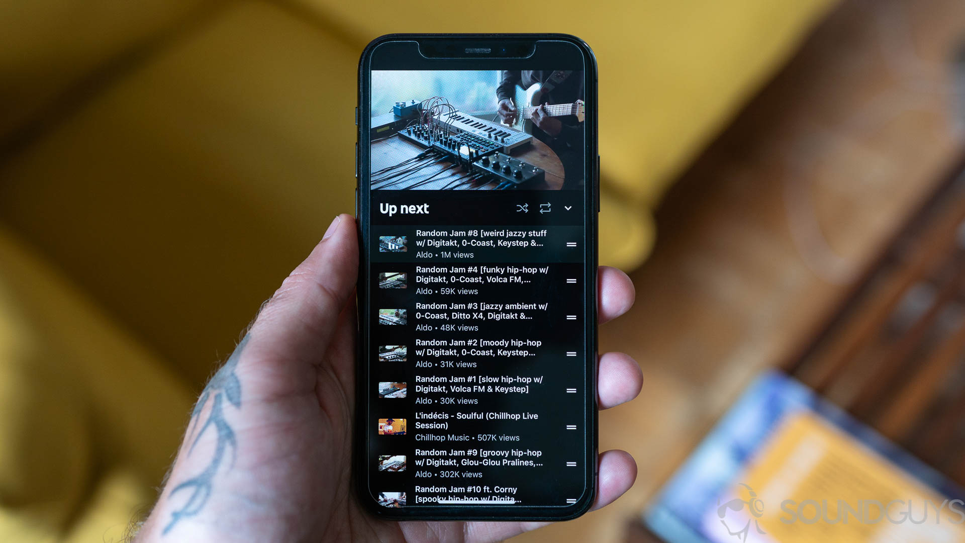 YouTube Music user content. Man holding iPhone 11 Pro with YouTube Music playing.