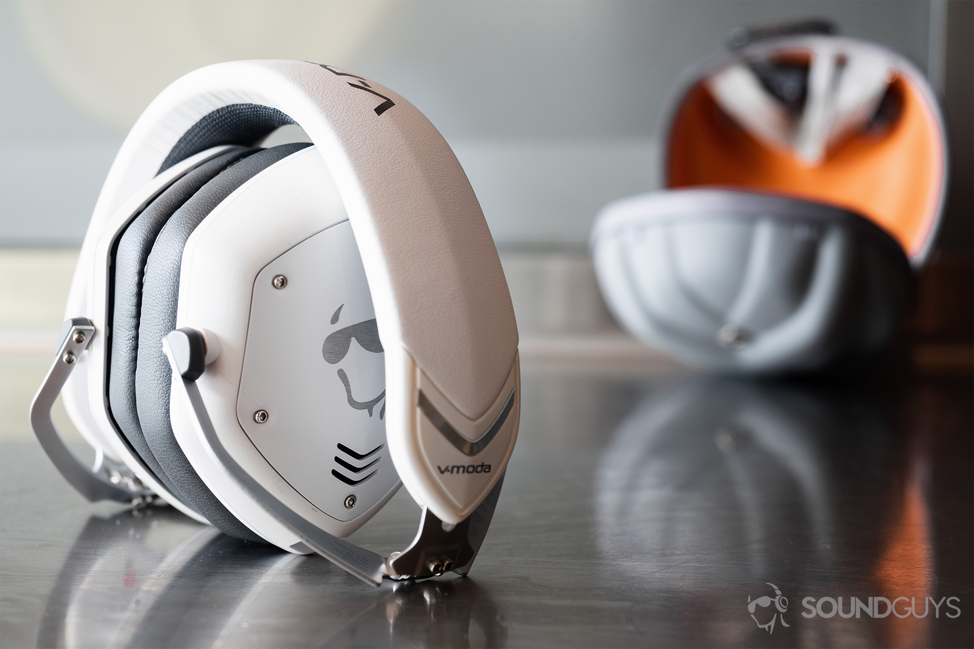 V-Moda_Crossfade 2 Codex-4 The V-Moda Crossfade 2 Codex headphones folded up but standing on a reflective surface wtih the clam shell Exoskeleton case in the background.