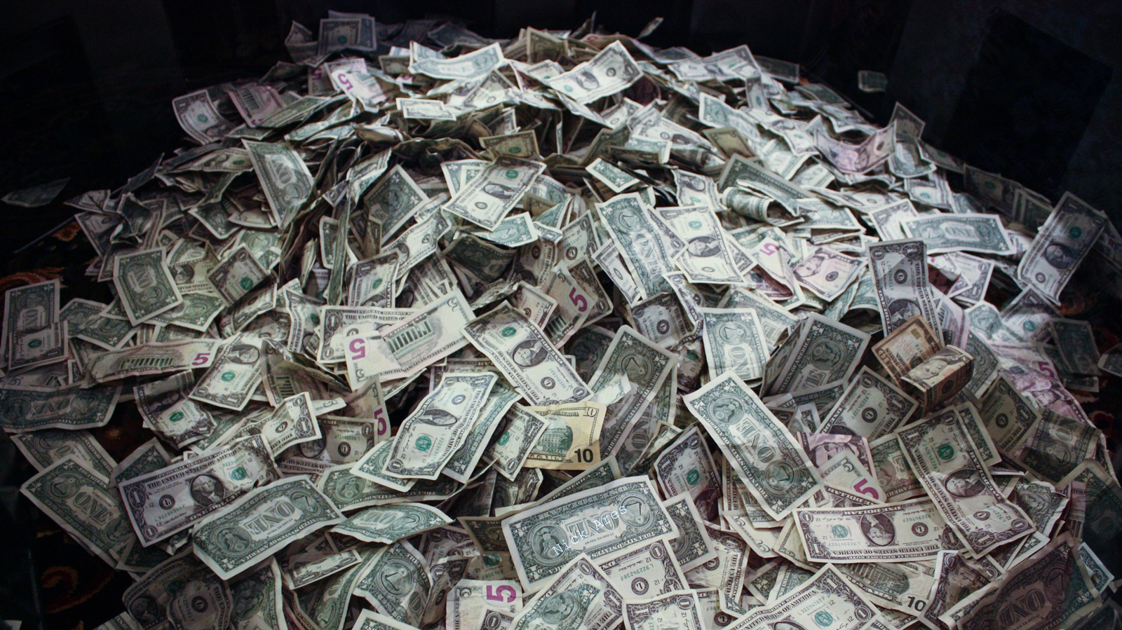 wired-headphones-bluetooth-headphones-money A photo of a pile of US dollar bills.