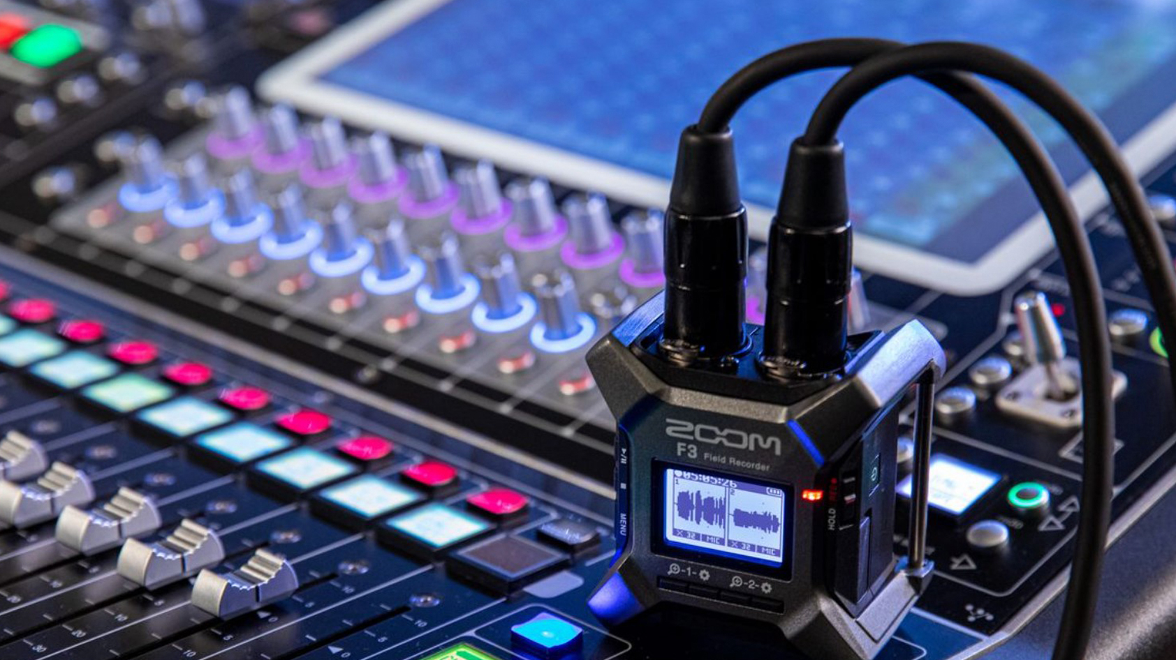 zoom-f3-field-recorder-on-mixing-board The Zoom F3 Field Recorder sits on a mixing board with two XLR cables connected.