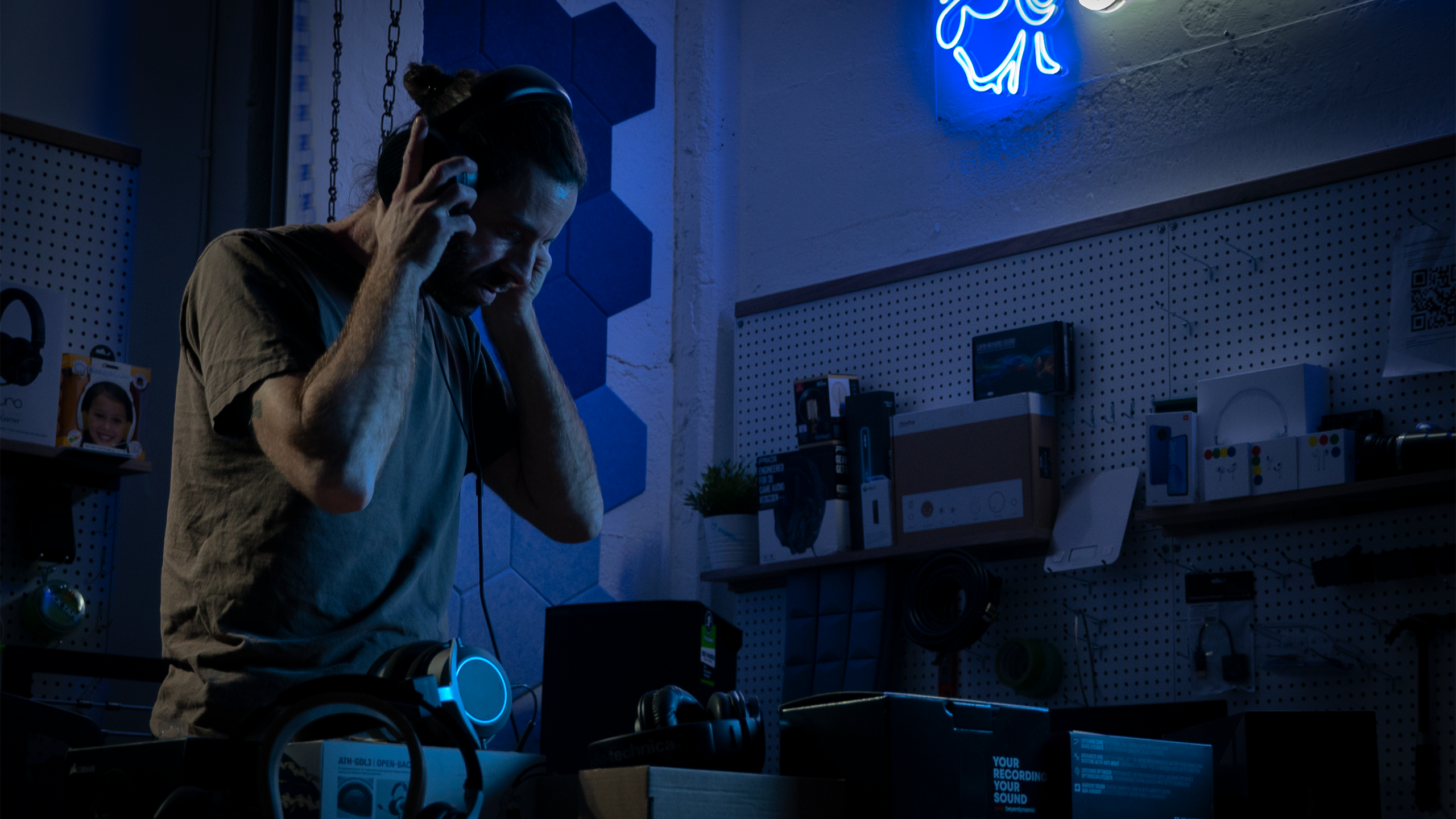 SoundGuys Mar2022 A headphone listener stands in a room.